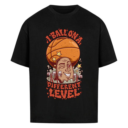 Schwarzes Oversized Basketball T-Shirt mit einem bunten Cartoon-Print einer zwinkernden Figur, die einen Basketball als Kopf hat. Der rote Text lautet „I BALL ON A DIFFERENT LEVEL“. 100% Baumwolle