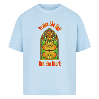 Babyblaues Oversized T-Shirt mit einem Print im Stil eines Kirchen-Buntglasfensters, der einen Basketball-Court zeigt. Darüber steht in Rot „Praise the Ball“ und darunter „Run the Court“. 100% Baumwolle.