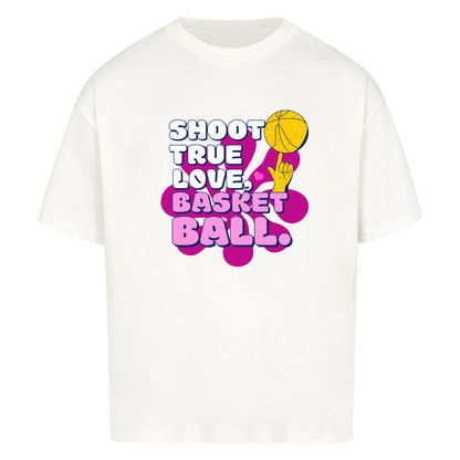 Weiß Oversized T-Shirt aus 100% Baumwolle mit einem pink-lila Retro-Print. Der Text lautet "SHOOT TRUE, LOVE, BASKETBALL" in Weiß mit dicken Rändern. Das Motiv zeigt einen Basketball und eine Hand.