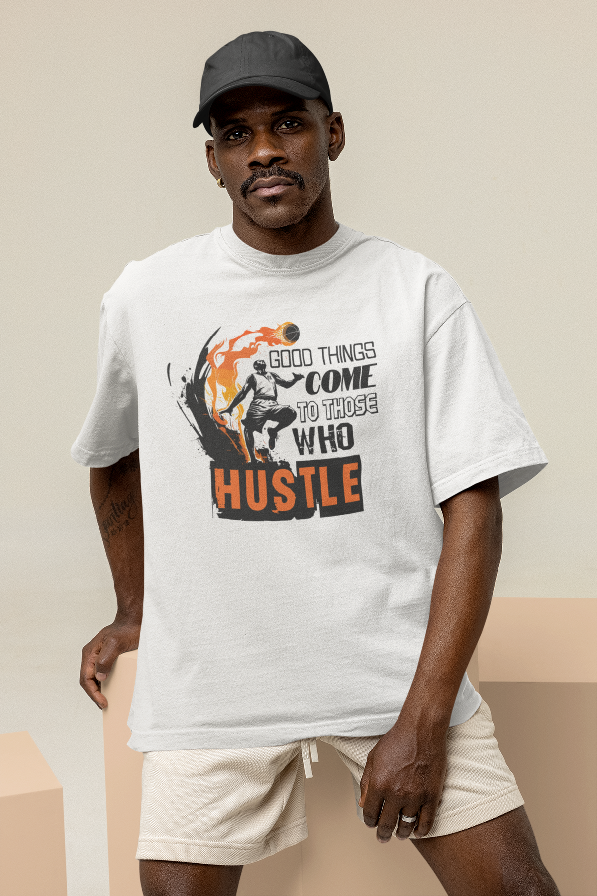 Mockup mit Model Weißes Oversized T-Shirt mit einem schwarz-orangen Print eines Basketballspielers in Flammen und dem motivierenden Spruch „GOOD THINGS COME TO THOSE WHO HUSTLE“. 100% Baumwolle.