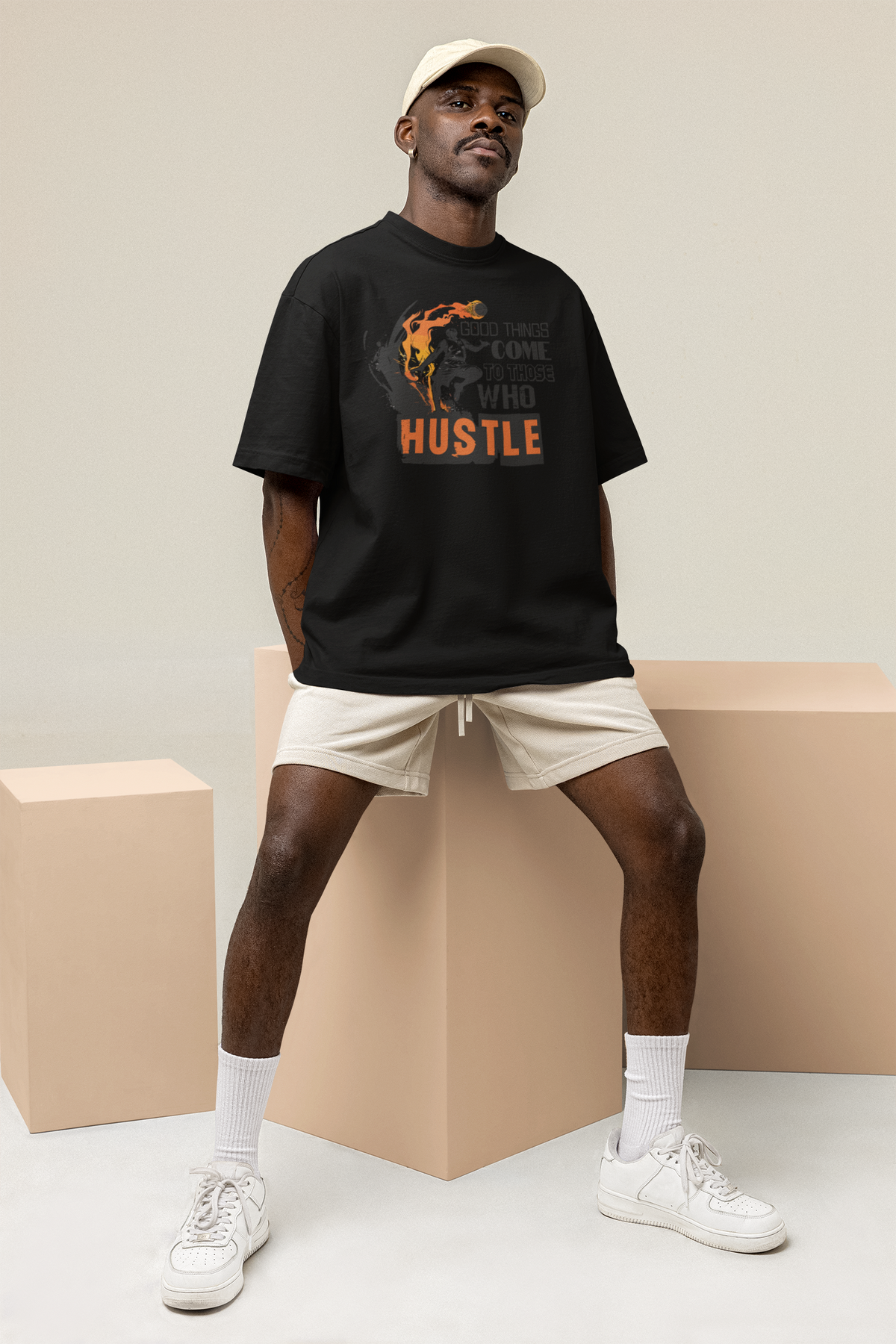 Mockup mit Model Schwarzes Oversized T-Shirt mit einem schwarz-orangen Print eines Basketballspielers in Flammen und dem motivierenden Spruch „GOOD THINGS COME TO THOSE WHO HUSTLE“. 100% Baumwolle.
